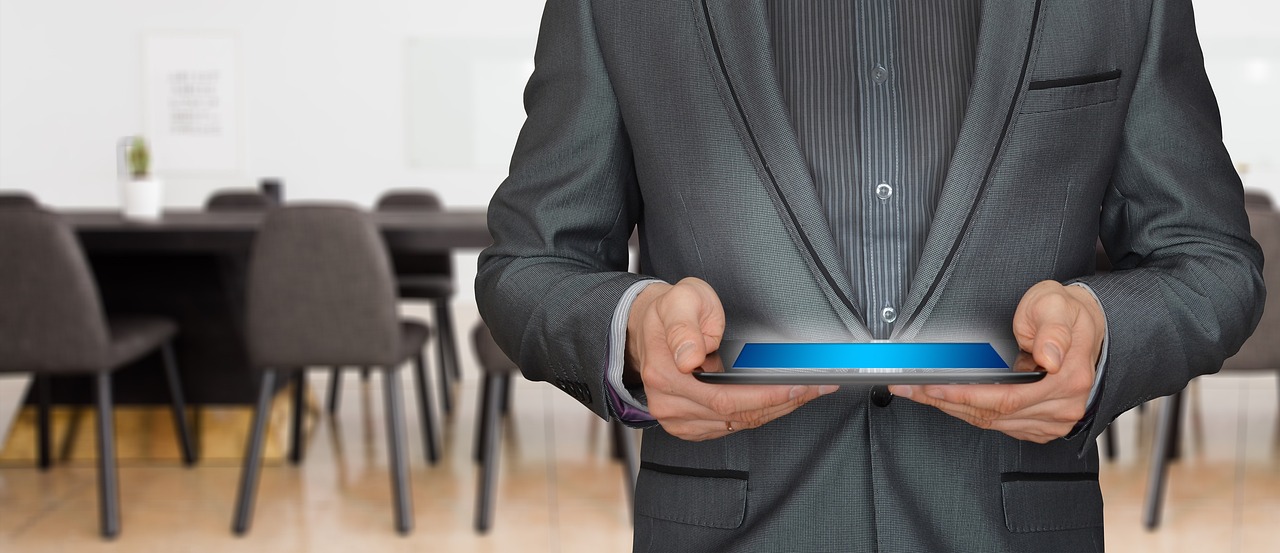 Empresário analisa no tablet as condições do plano de saúde empresarial em sala de reunião