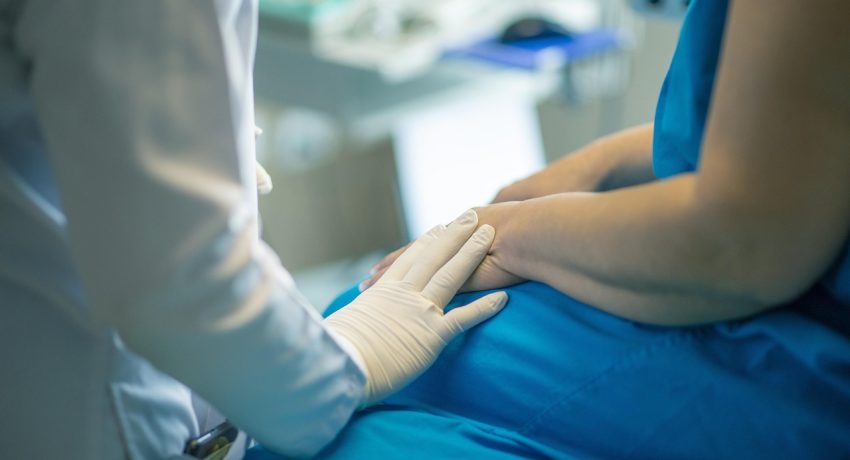 Profissional de saúde acolhe paciente durante atendimento em consultório antes de exame médico